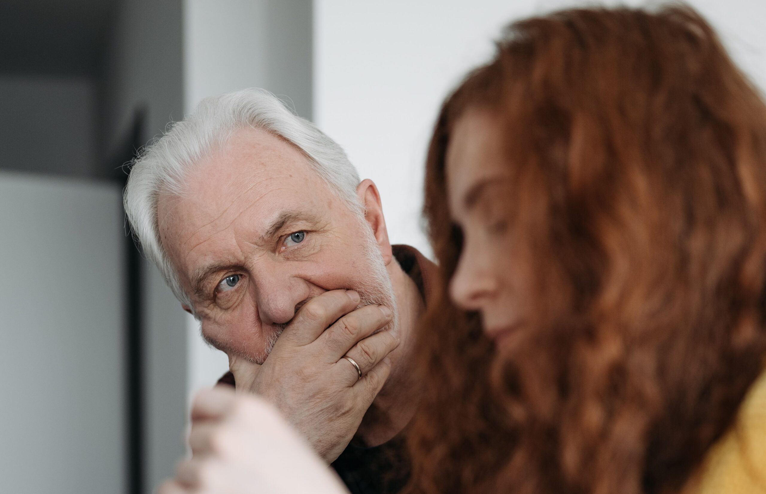 A mature man deep in thought in conversation with a young woman